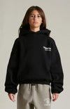 Black Fear of God Essentials Kids fleece hoodie featuring the Essentials logo on the front, soft and cozy for children.