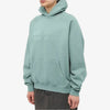 Fear of God Essentials hoodie in Sycamore color, featuring a relaxed fit and logo design, displayed on a hanger.