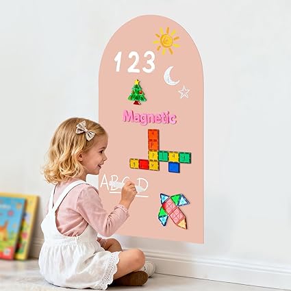 Child interacting with a magnetic learning board on a white wall