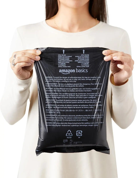 Woman holding disposable dog poop bags with dispenser and leash clip for easy pet waste cleanup.