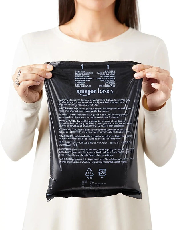 Woman holding disposable dog poop bags with dispenser and leash clip for easy pet waste cleanup.