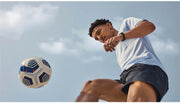 Boy wearing Fitbit Inspire 3 stylish fitness tracker playing with football.