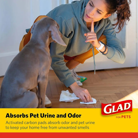 a woman cleaning dog waste after dog used Glad for Pets charcoal puppy pad.