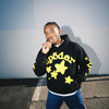 Black and yellow Sp5der Essential hoodie featuring star design, inspired by Young Thug streetwear style, by THE EA STORE.