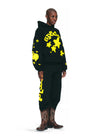 Black and yellow Sp5der Essential hoodie featuring star designs, worn by Young Thug streetwear style.
