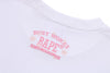 White and pink camo BAPE Sakura Ape Head Tee from THE EA STORE, featuring a printed ape head graphic on the front.