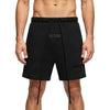 Black Fear of God Essentials sweat shorts in stretch limo fabric, casual style with elastic waistband and relaxed fit.