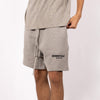 Dark oatmeal Fear of God Essentials sweat shorts with elastic waistband and relaxed fit, casual athletic style.