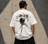 Black Widow 8-Ball graphic T-shirt by Stüssy in black and off-white, featuring bold graphic design and casual essentials style.