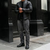 Men’s black genuine leather rider jacket with classic collar and silver hardware, styled on a mannequin.