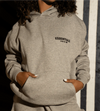 Dark oatmeal Fear of God Essentials hoodie from THE EA STORE, featuring a cozy, oversized fit and soft fabric, front view.