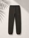 Black Fear of God Essentials sweatpants from THE EA STORE, showing the relaxed fit and soft fabric detail.