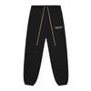 Black Fear of God Essentials sweatpants from THE EA STORE, featuring a relaxed fit and logo detail.