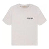 Light oatmeal Fear of God Essentials tee in 2XS from THE EA STORE, shown laid flat with soft fabric texture.