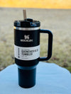 Stanley 40 oz Quencher H2.0 tumbler in black iridescent chrome with straw, vacuum insulated, spill-resistant, outdoors on blue surface